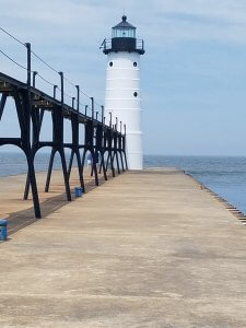 view of cement foundation and white north pier lighthouse in Muskegon, Mi