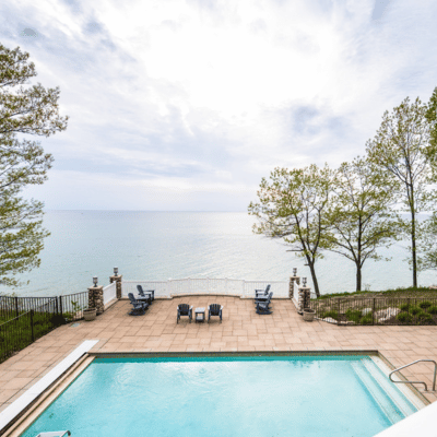 view of the private heated pool and lake michigan from a large vacation rental home