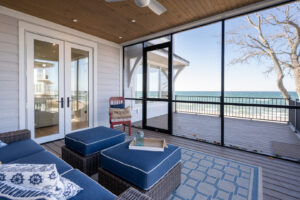 A three-season porch of a Lake Michigan vacation rental overlooking the beach.
